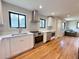 Bright kitchen features stainless steel appliances, white cabinets, and beautiful hardwood floors at 2895 Poplar St, Denver, CO 80207