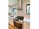 Close up view of range in a bright kitchen featuring stainless steel appliances and white cabinets at 2895 Poplar St, Denver, CO 80207