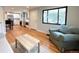 Open-concept living area with hardwood floors connecting to modern kitchen and large windows at 2895 Poplar St, Denver, CO 80207