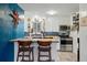 Well-lit kitchen featuring white cabinets, stainless steel appliances, and a cozy breakfast bar at 6755 W 33Rd Ave, Wheat Ridge, CO 80033