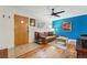 Inviting living room featuring hardwood floors, a ceiling fan, and a bright blue accent wall at 6755 W 33Rd Ave, Wheat Ridge, CO 80033