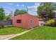 View of the backyard with a detached building featuring a green lawn, creating a private outdoor space at 869 S Williams St, Denver, CO 80209