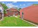 Brick home's backyard featuring a green lawn and a detached building, providing a private outdoor space at 869 S Williams St, Denver, CO 80209