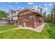 Brick home's backyard featuring a green lawn, a small garden, and a partially fenced area, enhancing privacy at 869 S Williams St, Denver, CO 80209