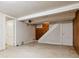 A clean basement with carpeted floors, offering a staircase, white trim and neutral-painted walls at 869 S Williams St, Denver, CO 80209