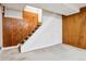 A staircase leading to the basement, complemented by paneled walls and carpeted floors at 869 S Williams St, Denver, CO 80209