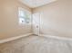 A cozy bedroom featuring neutral carpet and trim, bathed in natural light from a window at 869 S Williams St, Denver, CO 80209