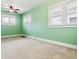 Bright bedroom with three large windows, plush carpet, and a ceiling fan at 869 S Williams St, Denver, CO 80209