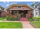 Inviting home exterior showcasing a brick facade, cozy front porch, and manicured landscaping at 869 S Williams St, Denver, CO 80209