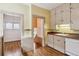 A functional kitchen with classic cabinets, a sink, and access to a hallway at 869 S Williams St, Denver, CO 80209