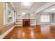 Spacious living room with hardwood floors, coffered ceiling, and a brick fireplace with bookshelves at 869 S Williams St, Denver, CO 80209