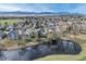 Aerial view of a residential community with mature trees and a pond at 6802 Poppy Ct, Arvada, CO 80007