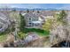 Aerial view of the home with a lush backyard, covered patio, and fire pit near the creek at 6802 Poppy Ct, Arvada, CO 80007