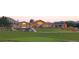Expansive golf course clubhouse with a manicured green, mountain views, and outdoor patio seating at 6802 Poppy Ct, Arvada, CO 80007