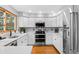Bright kitchen featuring white cabinetry, stainless steel appliances, and hardwood floors at 6802 Poppy Ct, Arvada, CO 80007
