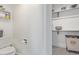Bright bathroom with a white toilet, a toilet paper holder, and a view into the walk-in closet at 9208 W 100Th Pl, Broomfield, CO 80021