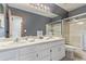 Bathroom with double sinks, a light gray wall, and a framed shower with glass doors at 9208 W 100Th Pl, Broomfield, CO 80021