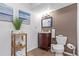 Bathroom with a dark wood vanity, tile floors, a mounted mirror, and ocean-themed artwork at 9208 W 100Th Pl, Broomfield, CO 80021