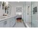 Bathroom with double vanity, modern fixtures, a glass shower enclosure and a glimpse into a bedroom at 9208 W 100Th Pl, Broomfield, CO 80021