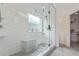 Modern bathroom with a glass enclosed shower, subway tile, shower bench, and gray mosaic tile flooring at 9208 W 100Th Pl, Broomfield, CO 80021