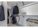 Walk-in closet with clothes hanging and folded on shelves with unique tile flooring at 9208 W 100Th Pl, Broomfield, CO 80021