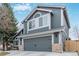 Side view of gray two-story home with a two-car garage and manicured landscape at 9208 W 100Th Pl, Broomfield, CO 80021