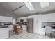 Bright kitchen with stainless steel refrigerator, white cabinets and countertops, tile floor, and skylights at 9208 W 100Th Pl, Broomfield, CO 80021