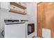 Laundry room with floating shelves and a full-size washer and dryer at 9208 W 100Th Pl, Broomfield, CO 80021
