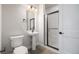 Modern bathroom featuring a pedestal sink, walk-in shower with black trim and fixtures at 888 S Valentia St # 104, Denver, CO 80247