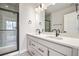 Modern bathroom featuring a double sink vanity, a shower with a glass door, and sleek fixtures at 888 S Valentia St # 104, Denver, CO 80247