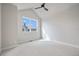 Bright bedroom featuring a ceiling fan, a large window, and neutral walls and carpet at 888 S Valentia St # 104, Denver, CO 80247