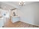 Dining area with wood floors near a kitchen with white cabinets, open floorplan and modern lighting at 888 S Valentia St # 104, Denver, CO 80247