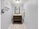 Neutral bathroom features a vanity with drawers and a decorative framed mirror and modern lighting at 6167 Newland St, Arvada, CO 80003