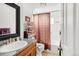 Bathroom featuring a granite countertop, shower-tub combo with curtain and safety bars at 6167 Newland St, Arvada, CO 80003