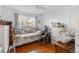 Cozy bedroom featuring hardwood floors, a vintage bedframe, and lots of natural light at 6167 Newland St, Arvada, CO 80003