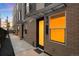 Stylish townhome exterior featuring brick facade, modern lighting, and sleek, covered entrance at 1836 Grove St # 105, Denver, CO 80204