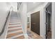 Hallway staircase with wood treads, adjacent to a bathroom and closet, enhancing home functionality at 1836 Grove St # 105, Denver, CO 80204