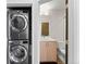 Convenient laundry area with stacked washer and dryer, adjacent to a well-lit bathroom at 1836 Grove St # 105, Denver, CO 80204