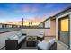 Inviting rooftop deck with cozy seating under string lights, creating a relaxing urban retreat with great sky views at 1836 Grove St # 105, Denver, CO 80204
