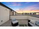 Rooftop deck space ideal for outdoor living, complete with comfortable seating and panoramic views during sunset at 1836 Grove St # 105, Denver, CO 80204