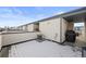 Spacious rooftop patio partially covered with snow, equipped with grill and air conditioner at 1836 Grove St # 105, Denver, CO 80204