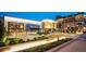 Evening view of a vibrant shopping center with illuminated storefronts and landscaped walkways at 200 N Pearl St # 205, Denver, CO 80203