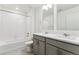 Well-lit bathroom featuring a dual sink vanity, bathtub with shower, and modern finishes at 1038 Scotts Peak Dr, Berthoud, CO 80513