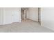 Carpeted bedroom view with a hallway, doorways, and a clean, neutral aesthetic at 1038 Scotts Peak Dr, Berthoud, CO 80513