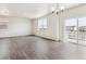 Bright living room with hard surface floors, white walls, and a glass sliding door to the balcony at 1038 Scotts Peak Dr, Berthoud, CO 80513