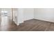 Spacious empty room featuring wood-look floors, white walls, and a doorway leading to a balcony at 1038 Scotts Peak Dr, Berthoud, CO 80513