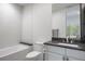 Clean bathroom with a white vanity, a gray countertop, a white tiled bathtub and a large mirror at 1207 Wildcat Bend Ct, Castle Rock, CO 80108