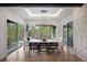 Dining room with a long table, modern chandelier, and sliding doors with natural light at 1207 Wildcat Bend Ct, Castle Rock, CO 80108