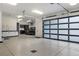 Spacious garage with epoxy floors, a modern frosted glass garage door, and a sink with white cabinetry at 1207 Wildcat Bend Ct, Castle Rock, CO 80108