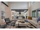 Open-concept living room with stone accents and connecting to a modern kitchen at 1207 Wildcat Bend Ct, Castle Rock, CO 80108